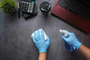 hands cleaning desk, office cleaning, office safety protocol